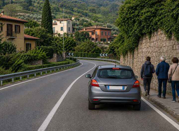 Automobile che rallenta prima di una curva con visibilità ridotta e presenza di pedoni vicino alla carreggiata